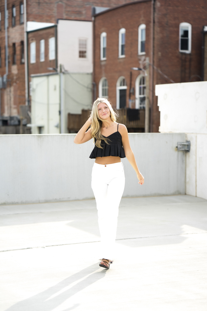 Downtown Buford Georgia Rooftop Parking Garage Senior Session with black top and white jeans.